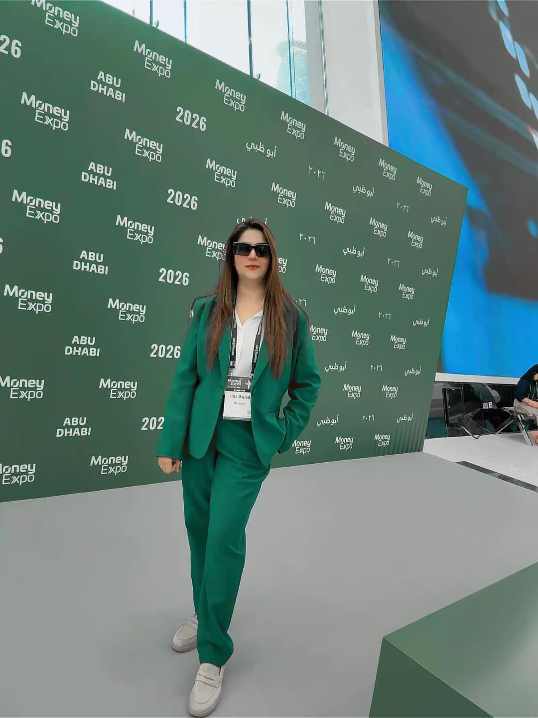 Hira Majeed photographed beside the Money Expo Abu Dhabi 2026 media wall